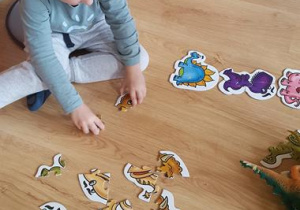 Chłopiec układa puzzle.